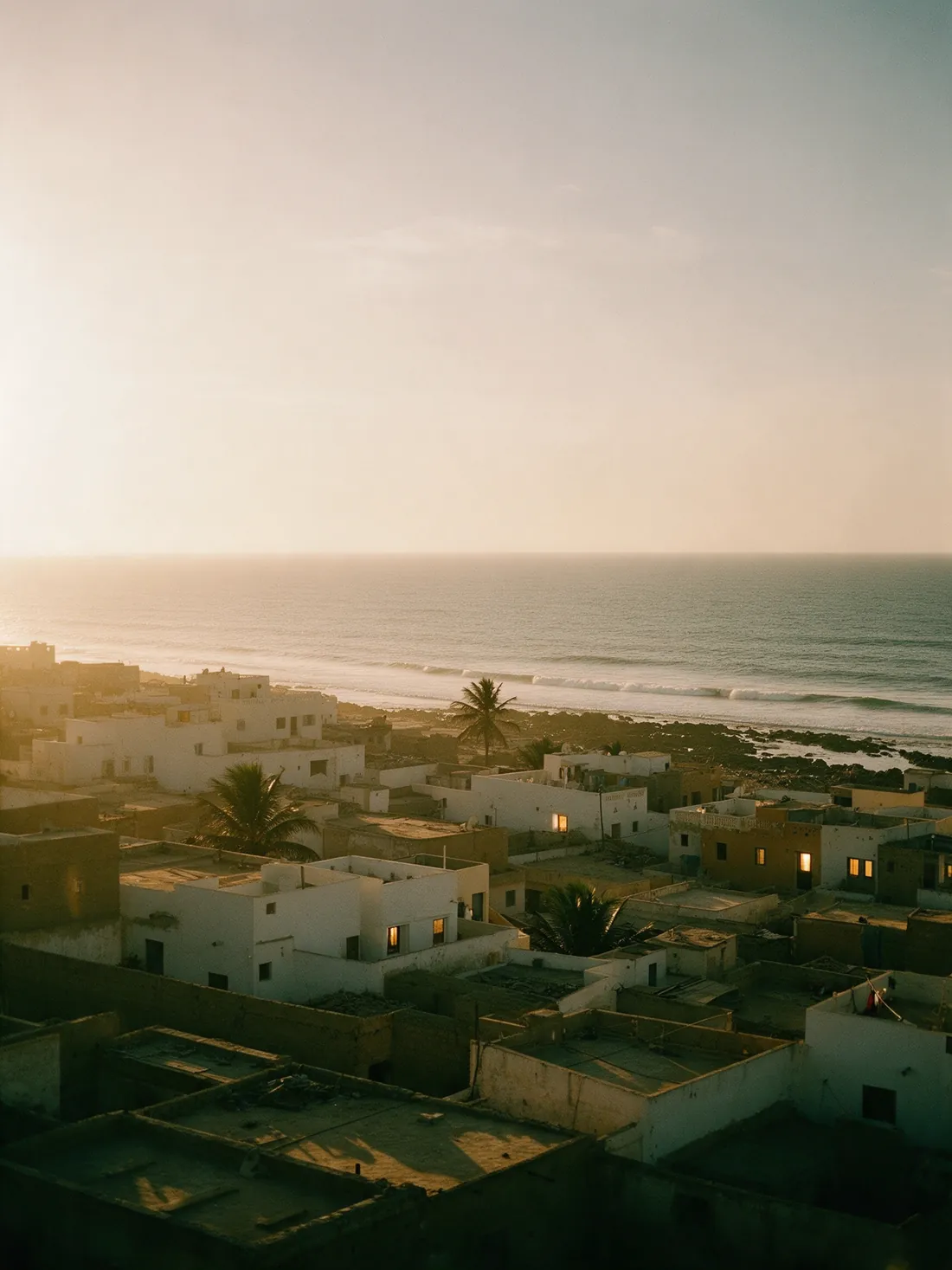 Les toits bas d'une ville côtière face à l'Atlantique, au crépuscule.